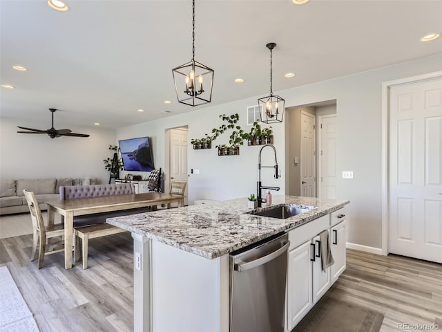 5995 Fencerow Pl, Brighton, CO 80601 - kitchen with stainless steel dishwasher, a sink, open floor plan, light wood-type flooring, and recessed lighting