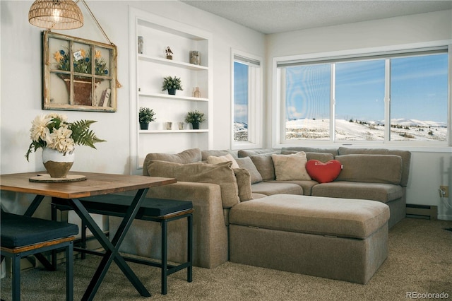 carpeted living room featuring a baseboard heating unit and built in shelves