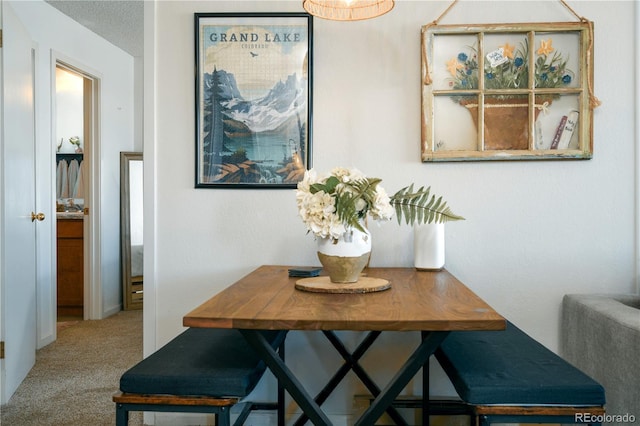 carpeted dining space with a textured ceiling