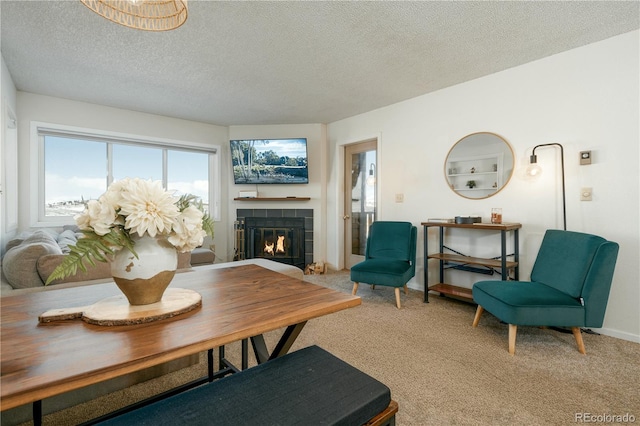 living room featuring carpet flooring, a fireplace, and a textured ceiling