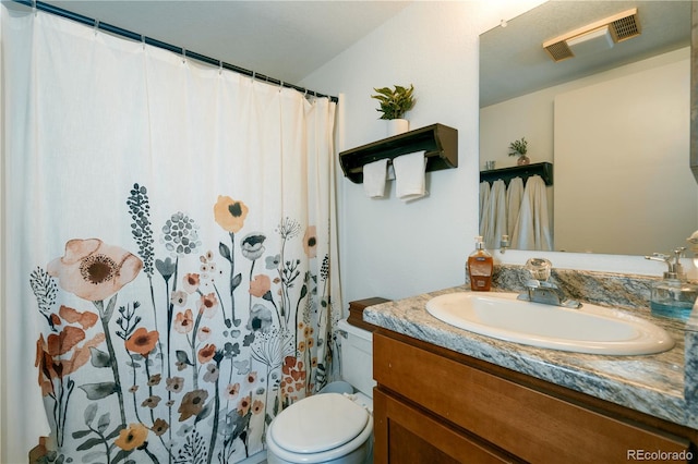 bathroom featuring vanity, toilet, and walk in shower