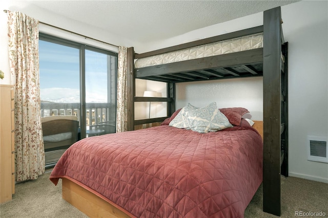 bedroom with light colored carpet and a textured ceiling