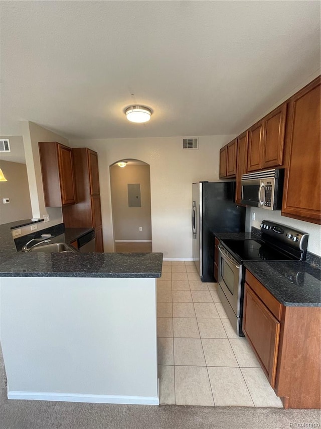 17346 Nature Walk Trl Unit 201, Parker, CO 80134 - kitchen featuring stainless steel appliances, a sink, brown cabinetry, a peninsula, and light tile patterned flooring