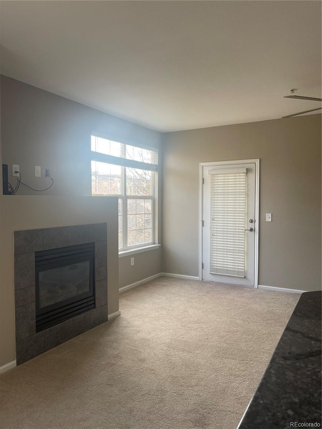 17346 Nature Walk Trl Unit 201, Parker, CO 80134 - unfurnished living room featuring carpet floors, a tile fireplace, and baseboards