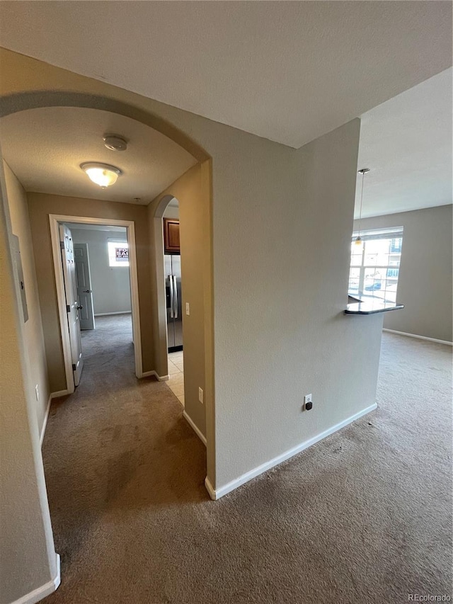 17346 Nature Walk Trl Unit 201, Parker, CO 80134 - hall with light colored carpet, arched walkways, and baseboards