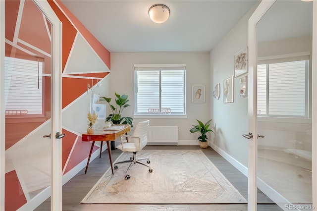 office space featuring french doors, a healthy amount of sunlight, and radiator