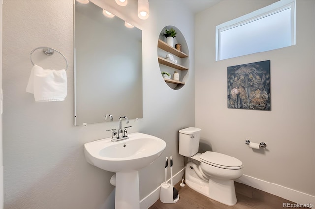 bathroom featuring built in shelves, toilet, and hardwood / wood-style flooring