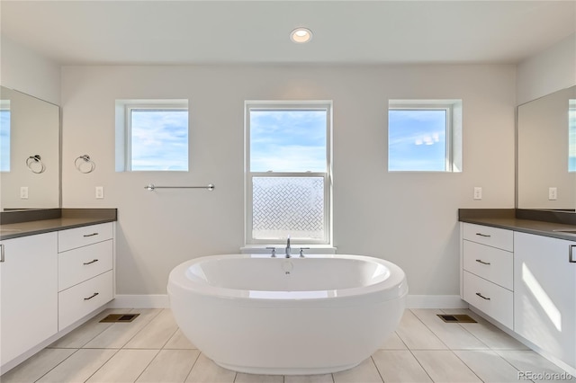 bathroom featuring vanity, tile patterned flooring, and a washtub