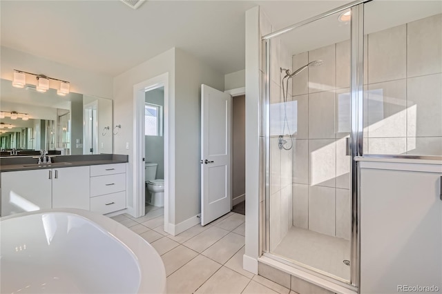 full bathroom with tile patterned flooring, shower with separate bathtub, vanity, and toilet