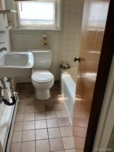 420 E 45th Ave, Denver, CO 80216 - bathroom featuring toilet, tile patterned floors, a tub to relax in, and a sink