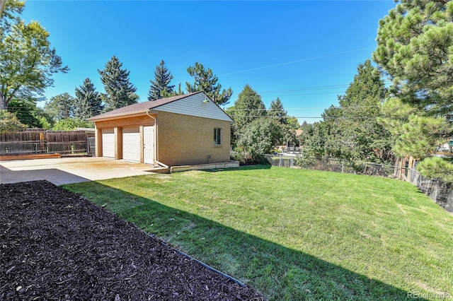 view of yard with a garage and an outbuilding