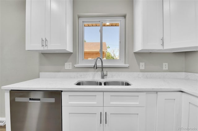 kitchen featuring dishwasher, light stone counters, white cabinetry, and sink