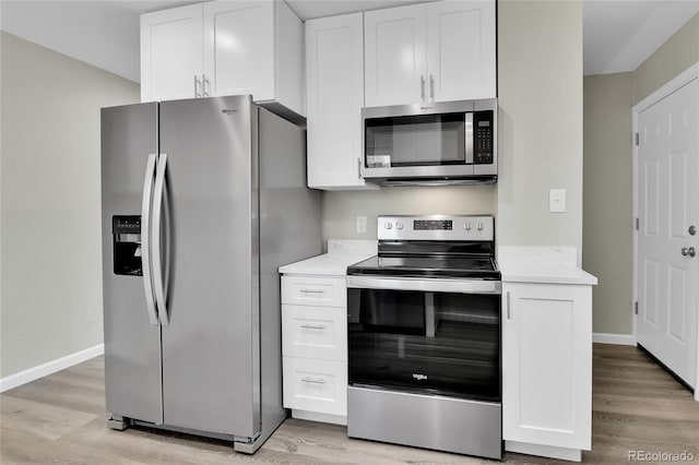 kitchen featuring white cabinets, stainless steel appliances, and light hardwood / wood-style flooring