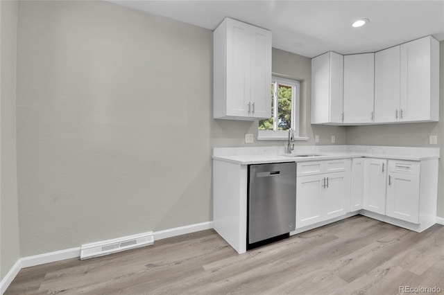 kitchen featuring white cabinets, light hardwood / wood-style flooring, stainless steel dishwasher, and sink