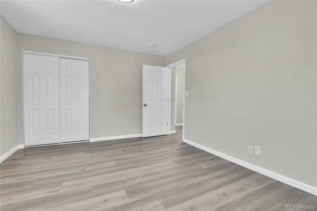 unfurnished bedroom featuring a closet and light hardwood / wood-style flooring