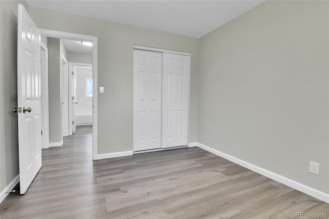 unfurnished bedroom featuring light hardwood / wood-style flooring and a closet