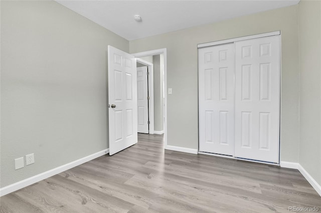 unfurnished bedroom with a closet and light hardwood / wood-style flooring