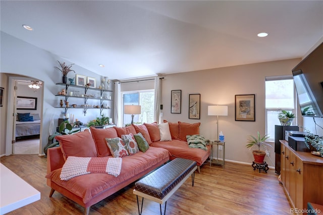 20194 Robins Dr, Denver, CO 80249 - living area featuring light wood-style flooring, lofted ceiling, baseboards, arched walkways, and recessed lighting
