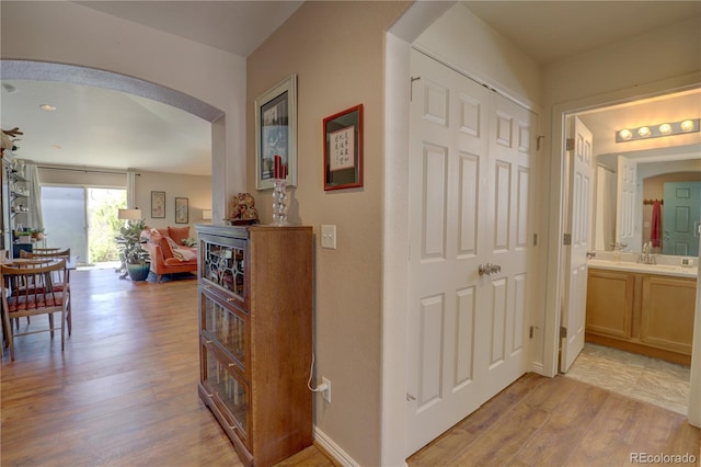 20194 Robins Dr, Denver, CO 80249 - hallway with arched walkways and light wood-style flooring