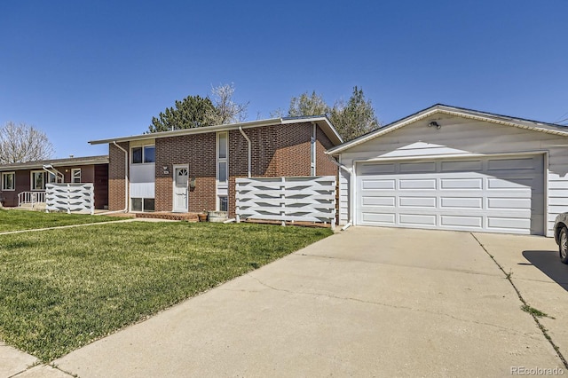 view of front facade with brick siding, a front lawn, fence, and concrete driveway