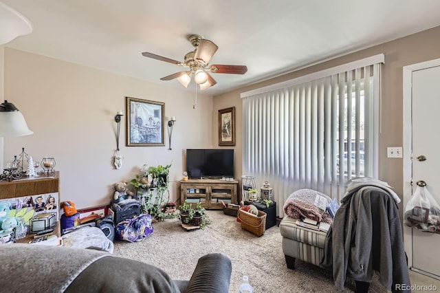 living area with ceiling fan and carpet