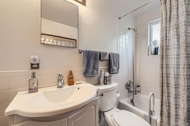 bathroom featuring vanity, tile walls, toilet, and shower / bathtub combination with curtain