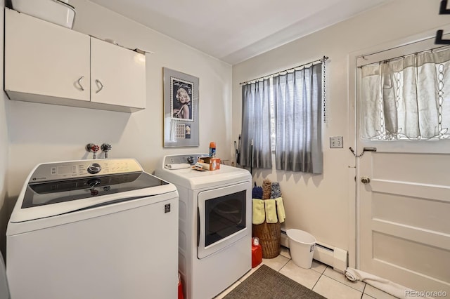 clothes washing area featuring plenty of natural light, cabinet space, light tile patterned floors, and washing machine and dryer