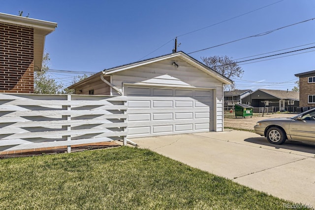 view of side of property featuring a garage, fence, and an outbuilding
