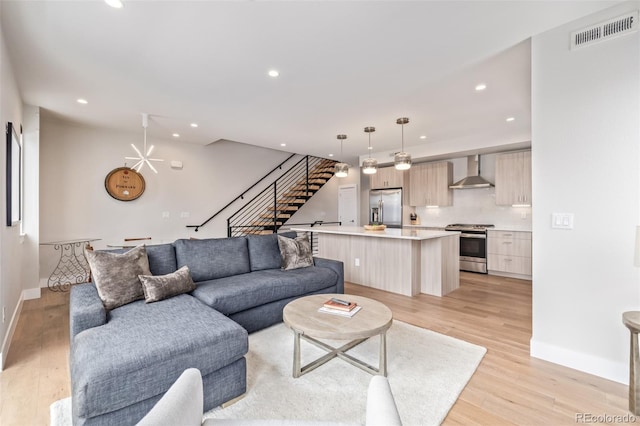 living room with a chandelier and light hardwood / wood-style floors