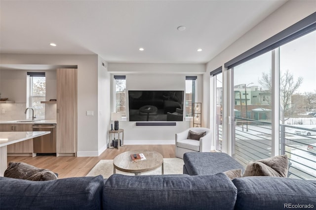 living room featuring sink and light hardwood / wood-style flooring