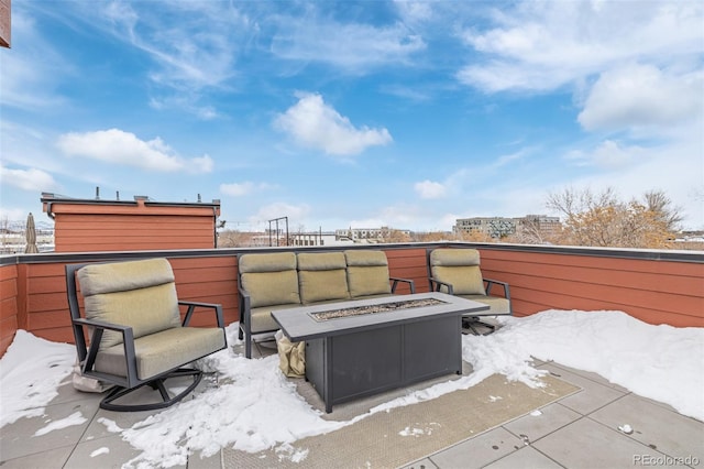 snow covered patio featuring a fire pit