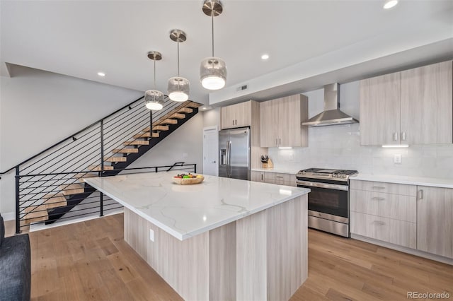 2350 Tremont Pl Unit 13, Denver, CO 80205 - kitchen featuring stainless steel appliances, wall chimney range hood, modern cabinets, light wood finished floors, and recessed lighting