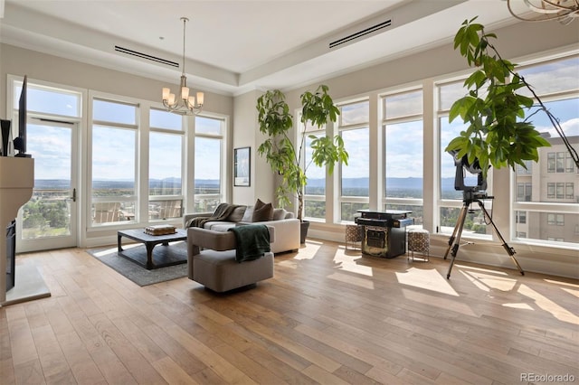 living room with light hardwood / wood-style flooring and an inviting chandelier