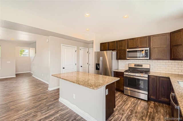 7263 Horsechestnut St, Wellington, CO 80549 - kitchen featuring appliances with stainless steel finishes, dark wood finished floors, baseboards, decorative backsplash, and recessed lighting