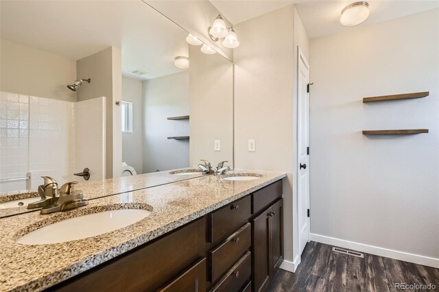 7263 Horsechestnut St, Wellington, CO 80549 - full bathroom with double vanity, wood finished floors, baseboards, a shower, and toilet