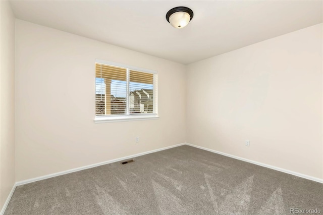 empty room featuring carpet floors, visible vents, and baseboards