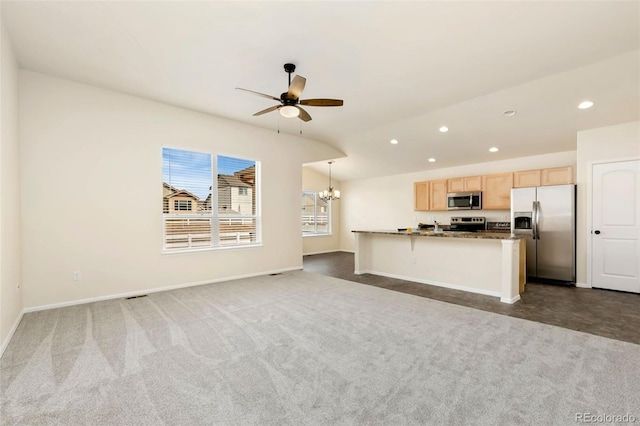 kitchen with recessed lighting, light brown cabinetry, appliances with stainless steel finishes, open floor plan, and vaulted ceiling