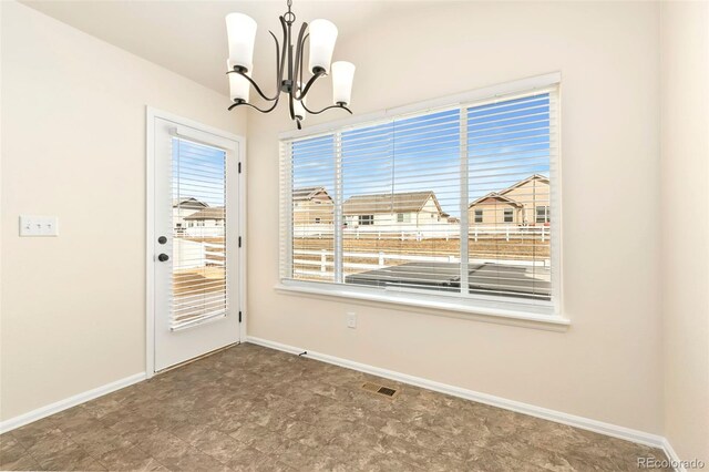 unfurnished dining area with baseboards, visible vents, and an inviting chandelier