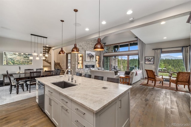60 Barton Ridge Dr, Breckenridge, CO 80424 - kitchen featuring dark wood-type flooring, a fireplace, light stone counters, dishwasher, and pendant lighting