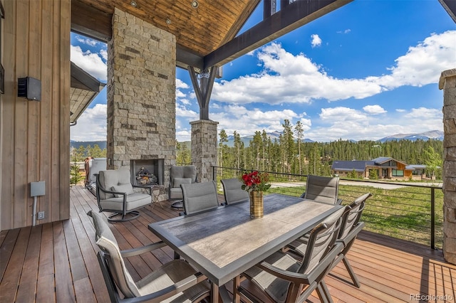 60 Barton Ridge Dr, Breckenridge, CO 80424 - deck featuring an outdoor stone fireplace, a mountain view, and outdoor dining space