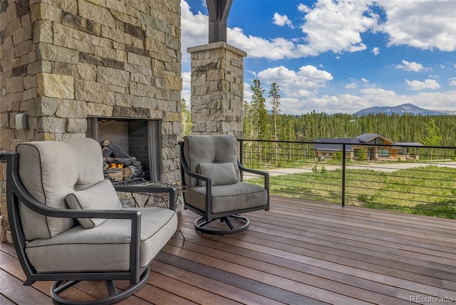 60 Barton Ridge Dr, Breckenridge, CO 80424 - deck featuring an outdoor stone fireplace and a mountain view
