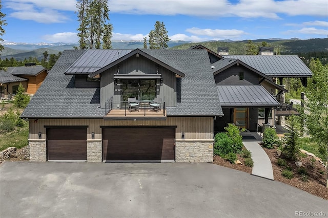60 Barton Ridge Dr, Breckenridge, CO 80424 - view of front of home featuring stone siding, a standing seam roof, a mountain view, and a garage