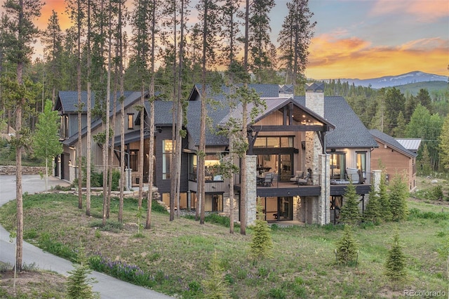 60 Barton Ridge Dr, Breckenridge, CO 80424 - contemporary home with a chimney, concrete driveway, an attached garage, and a deck with mountain view