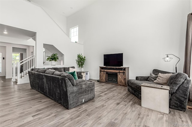 24326 E Ohio Dr, Aurora, CO 80018 - living area featuring light wood-style flooring, stairs, and a high ceiling