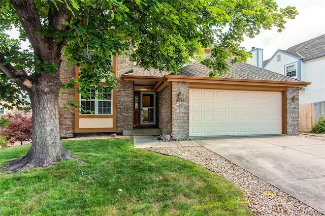 9614 W Powers Cir, Littleton, CO 80123 - view of front of home featuring an attached garage, driveway, brick siding, and a front yard
