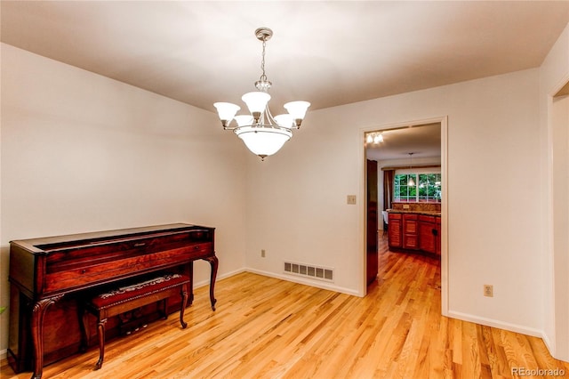9614 W Powers Cir, Littleton, CO 80123 - unfurnished room featuring a chandelier and light wood-style floors