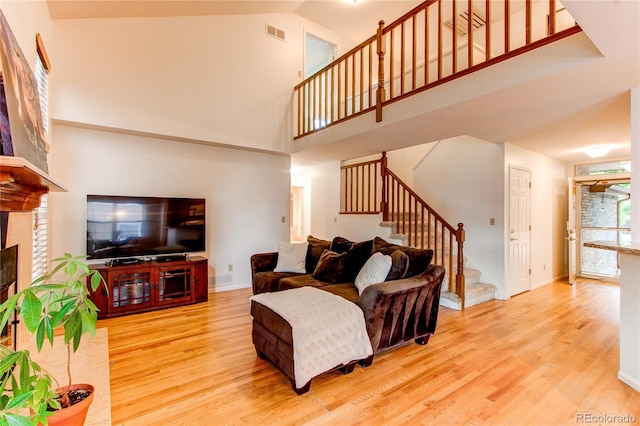 9614 W Powers Cir, Littleton, CO 80123 - living area with stairway, wood finished floors, a fireplace, and a high ceiling
