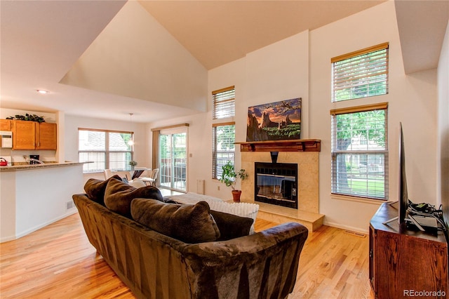 9614 W Powers Cir, Littleton, CO 80123 - living room with light wood-style floors, a tile fireplace, and a high ceiling