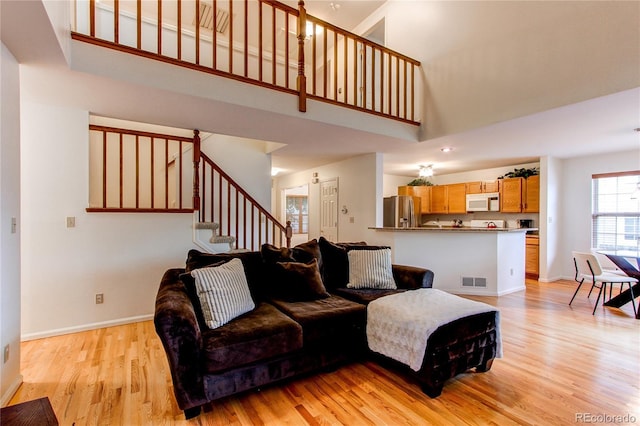 9614 W Powers Cir, Littleton, CO 80123 - living area featuring light wood finished floors, a high ceiling, and stairway