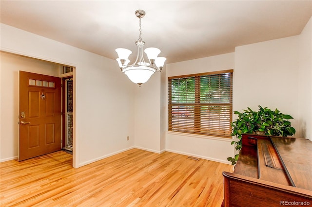 9614 W Powers Cir, Littleton, CO 80123 - unfurnished room featuring a chandelier and light wood-style flooring